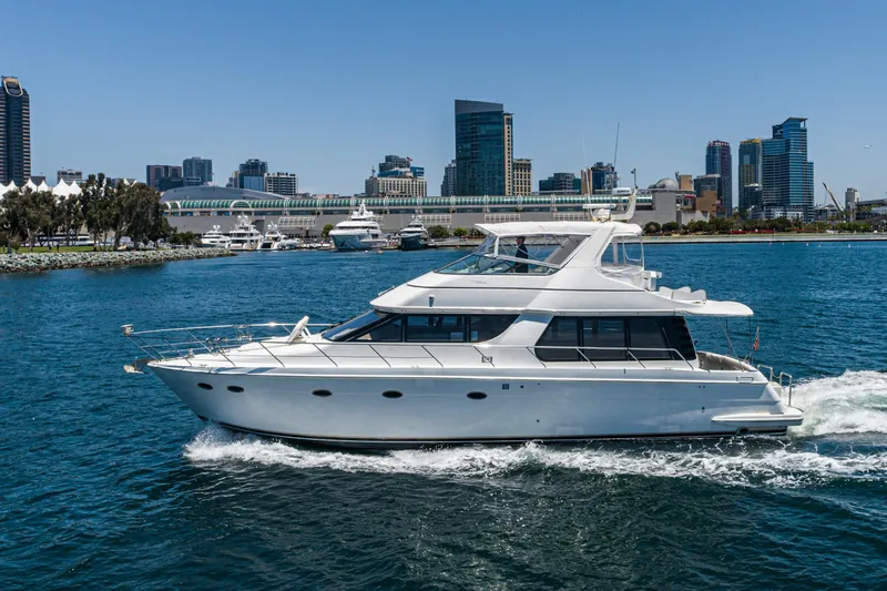 Slide: The Image of 1999 Carver 530 Voyager Pilothouse yacht cruising near city skyline. - 47