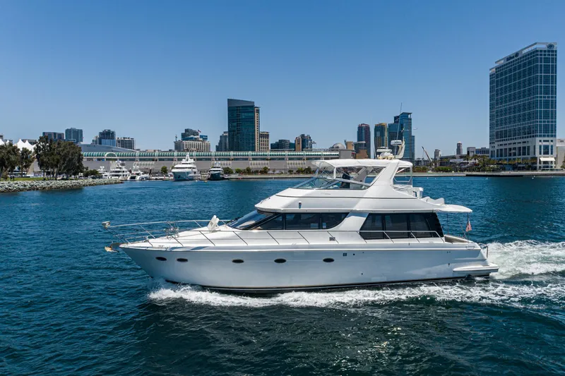 Slide: The Image of 1999 Carver 530 Voyager Pilothouse yacht cruising near city skyline. - 48