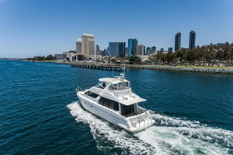 Slide: The Image of 1999 Carver 530 Voyager Pilothouse yacht cruising near city skyline. - 49