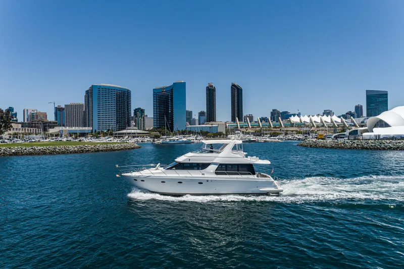 Slide: The Image of 1999 Carver 530 Voyager Pilothouse yacht cruising near city skyline. - 6