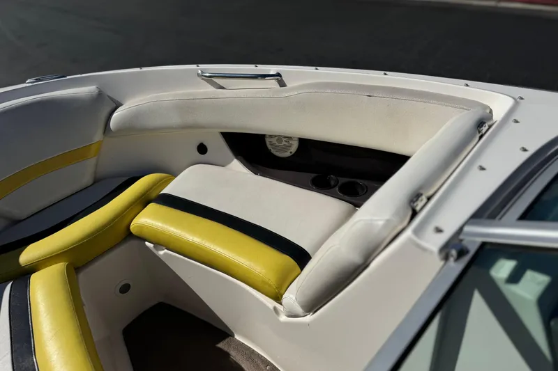Slide: The Image of Interior seating of a 2005 Regal 2200 Bowrider boat with yellow accents. - 14