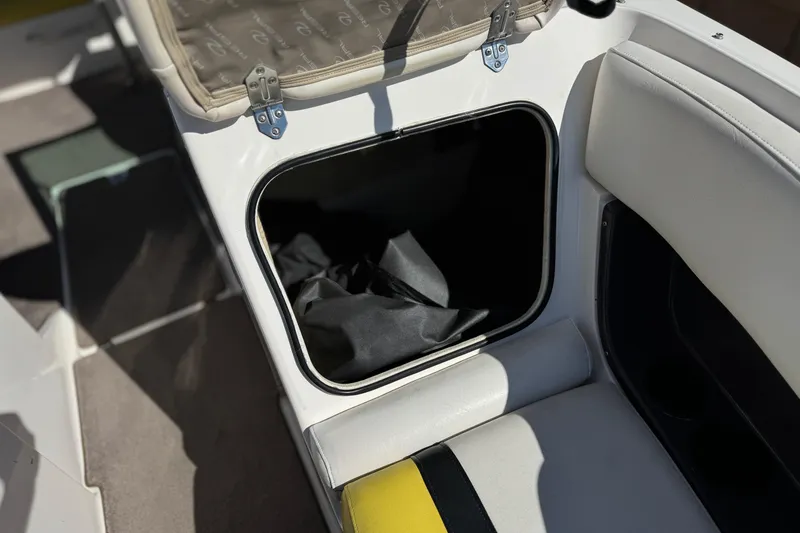 Slide: The Image of Storage compartment in a 2005 Regal 2200 Bowrider boat, featuring cushioned seating. - 15