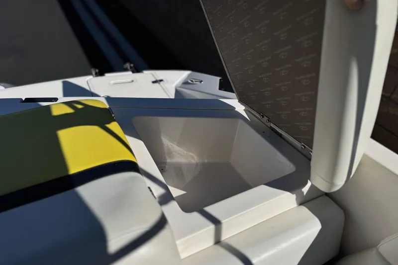 Slide: The Image of Open storage compartment on a 2005 Regal 2200 Bowrider boat, featuring yellow seat accents. - 21
