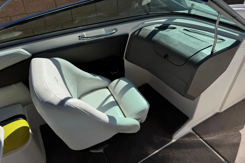 Slide: The Image of Interior of a 2005 Regal 2200 Bowrider boat, featuring a white captain's chair. - 25