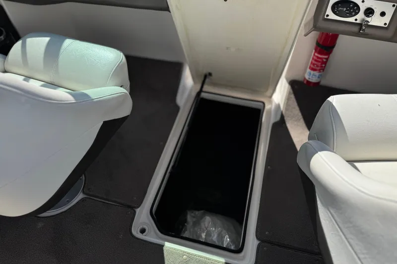 Slide: The Image of 2005 Regal 2200 Bowrider interior with storage compartment and white seating. - 27