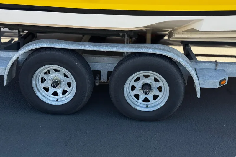 Slide: The Image of Trailer wheels of a 2005 Regal 2200 Bowrider boat on pavement. - 30