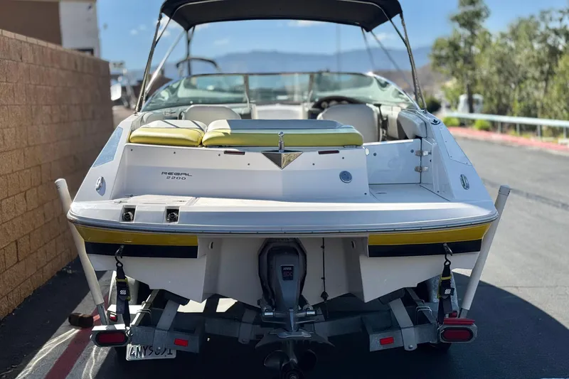 Slide: The Image of 2005 Regal 2200 Bowrider boat on trailer, rear view, parked outdoors. - 4