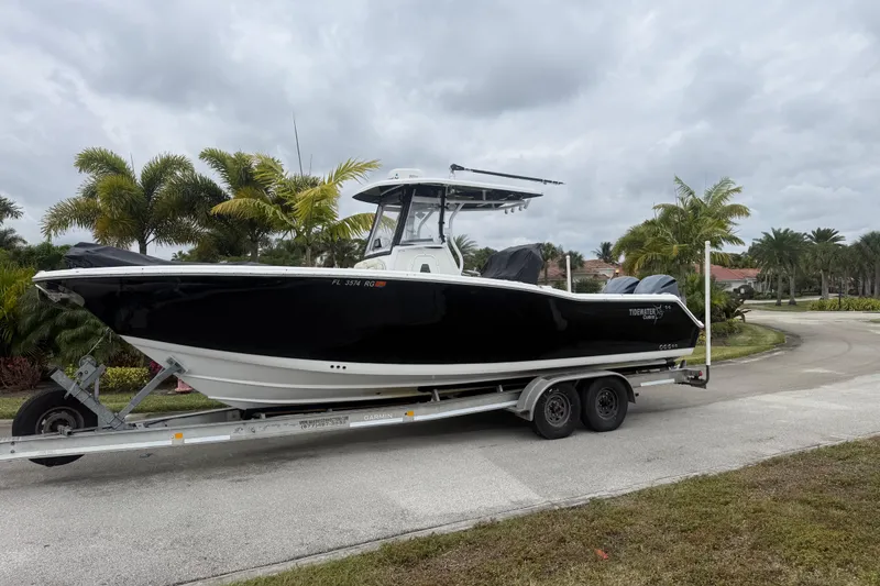 The Image of 2017 Tidewater 280 CC Adventure boat on trailer, surrounded by palm trees. - 0