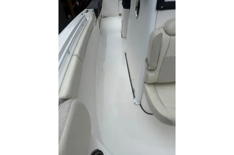 Slide: The Image of Interior view of a 2017 Tidewater 280 CC Adventure boat, featuring white seating and flooring. - 10