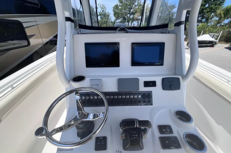 Slide: The Image of 2017 Tidewater 280 CC Adventure boat helm with dual screens and steering wheel. - 13