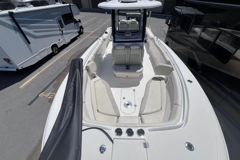 Slide: The Image of 2017 Tidewater 280 CC Adventure boat interior with seating, parked near RVs. - 15