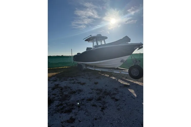 Slide: The Image of 2017 Tidewater 280 CC Adventure boat on trailer under sunny sky. - 2