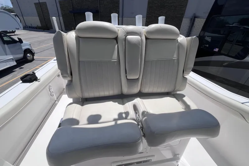 Slide: The Image of 2017 Tidewater 280 CC Adventure boat seating, featuring plush white upholstery in a marina setting. - 22