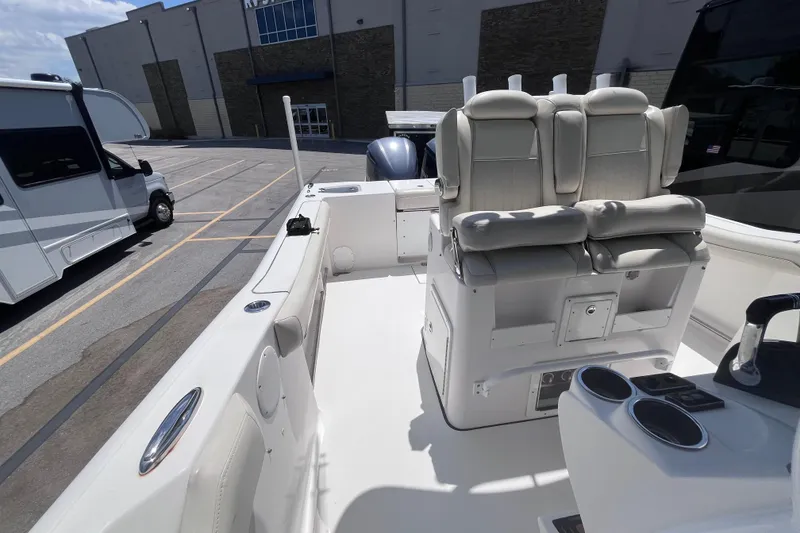 Slide: The Image of 2017 Tidewater 280 CC Adventure boat interior with seating and storage, parked near RV. - 23