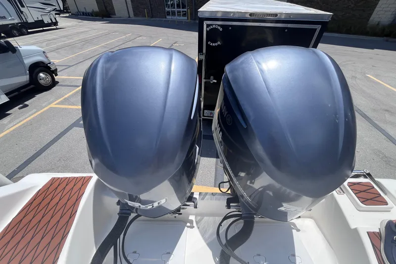 Slide: The Image of Twin outboard motors on a 2017 Tidewater 280 CC Adventure boat in a parking lot. - 26