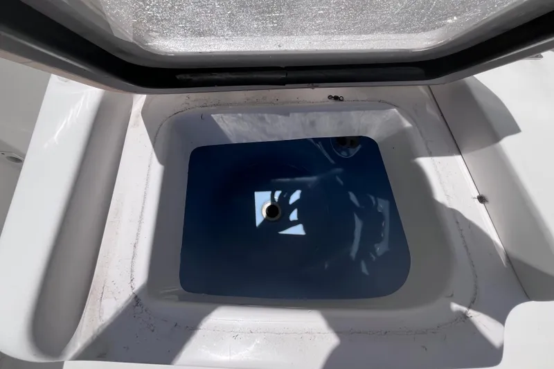 Slide: The Image of Livewell compartment on a 2017 Tidewater 280 CC Adventure boat, open lid view. - 32