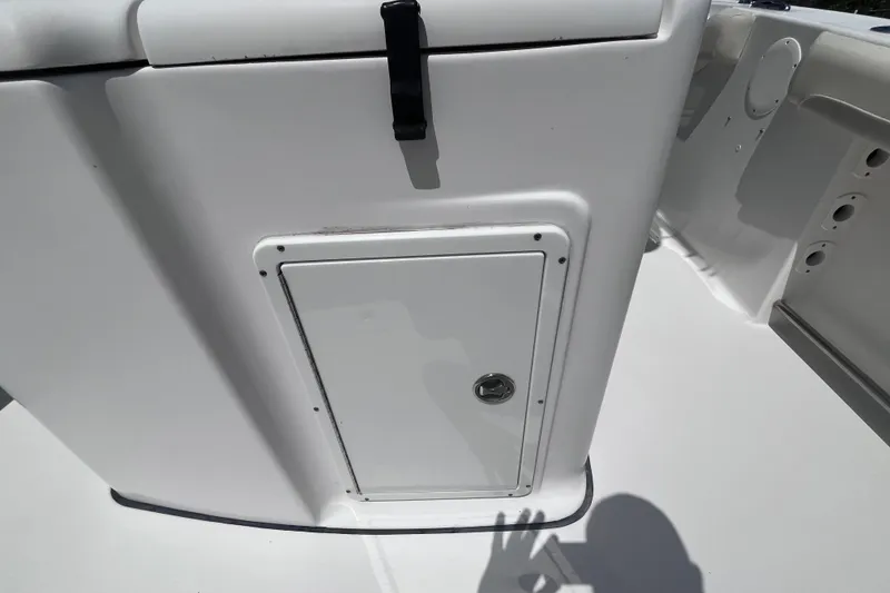 Slide: The Image of 2017 Tidewater 280 CC Adventure boat storage compartment with latch and shadow. - 36