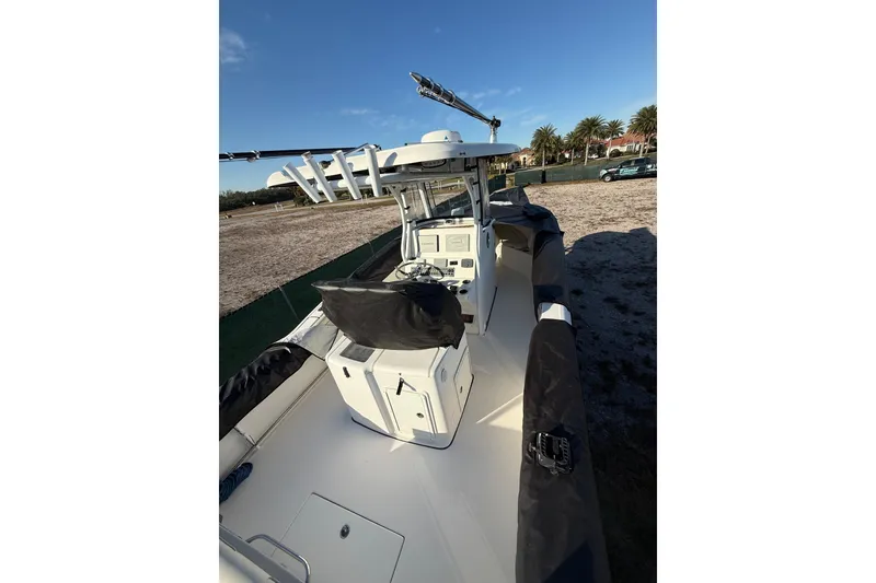 Slide: The Image of 2017 Tidewater 280 CC Adventure boat with covered seating and console, parked outdoors. - 5