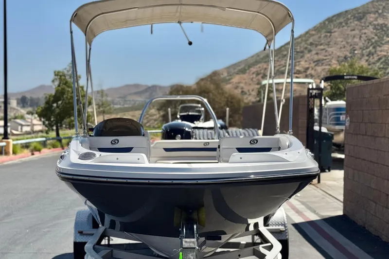 Slide: The Image of 2022 Hurricane SunDeck Sport 185 OB boat on trailer, scenic mountain backdrop. - 2