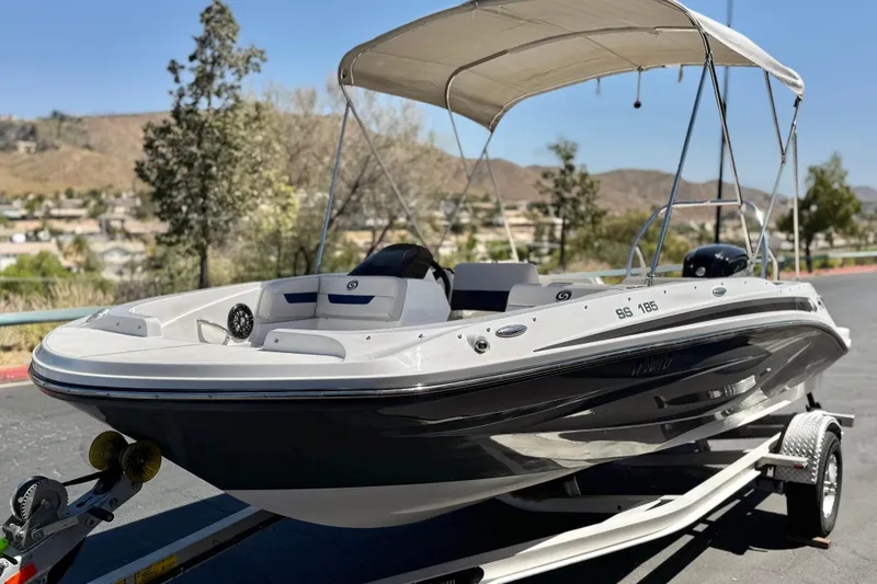 Slide: The Image of 2022 Hurricane SunDeck Sport 185 OB boat on trailer, parked outdoors. - 3