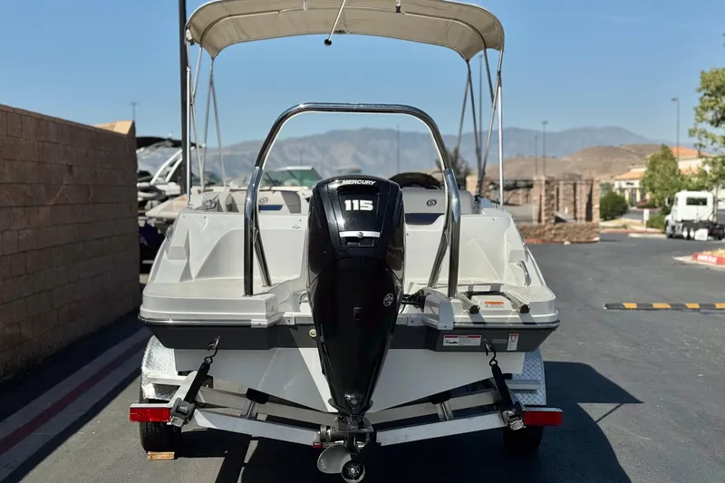 Slide: The Image of 2022 Hurricane SunDeck Sport 185 OB boat with Mercury 115 engine, parked outdoors. - 4