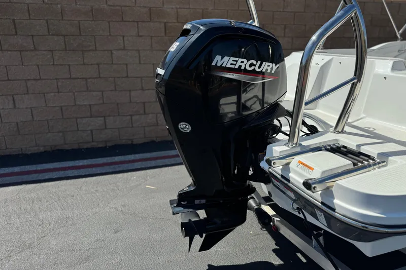 Slide: The Image of 2022 Hurricane SunDeck Sport 185 OB with Mercury outboard motor, parked on pavement. - 6