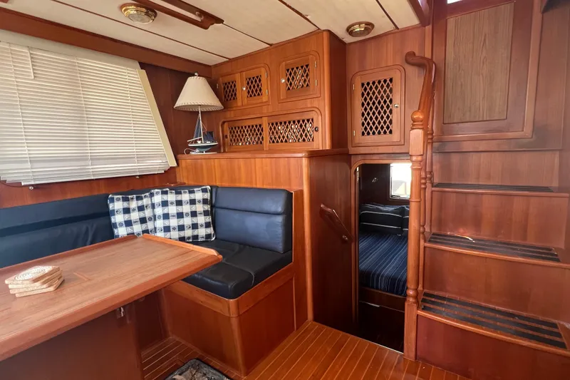 Slide: The Image of 2007 Heritage East Sundeck Trawler interior with wood finish, seating, and stairs. - 10