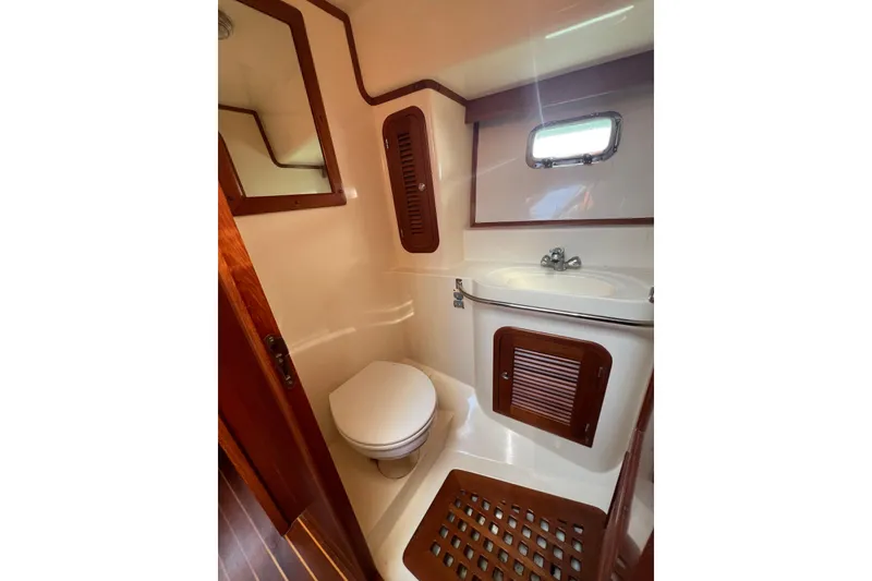 Slide: The Image of Bathroom interior of 2007 Heritage East Sundeck Trawler with wooden accents and compact design. - 18