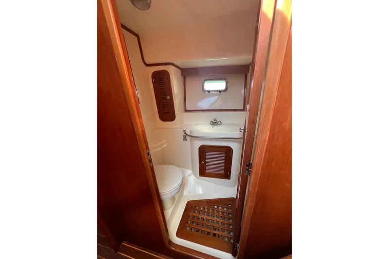 Slide: The Image of 2007 Heritage East Sundeck Trawler bathroom with wooden accents and compact design. - 19