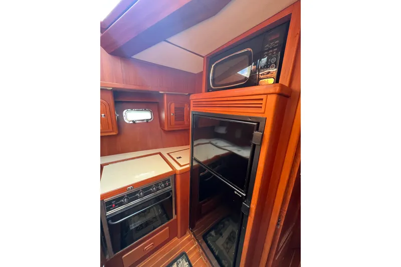 Slide: The Image of 2007 Heritage East Sundeck Trawler kitchen with wood cabinetry, oven, and microwave. - 22