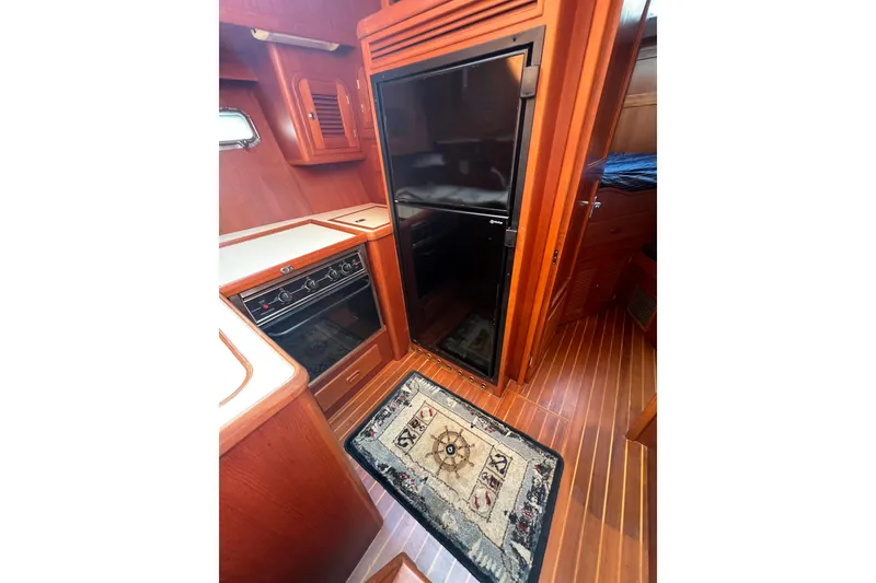 Slide: The Image of 2007 Heritage East Sundeck Trawler interior with wood finish and kitchen appliances. - 23