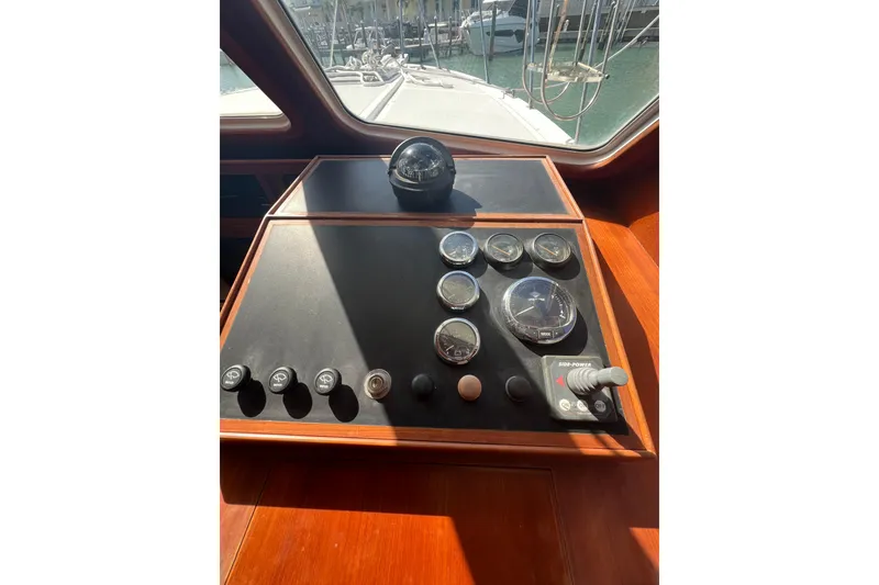 Slide: The Image of 2007 Heritage East Sundeck Trawler helm with gauges and controls, docked in marina. - 24