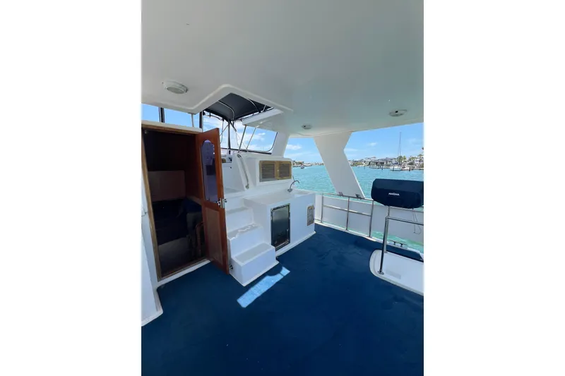 Slide: The Image of 2007 Heritage East Sundeck Trawler with spacious deck, blue carpet, and marina view. - 4