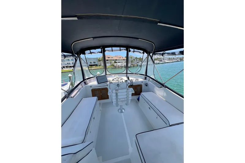 Slide: The Image of 2007 Heritage East Sundeck Trawler interior with seating, helm, and marina view. - 6