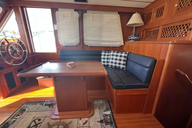 Slide: The Image of Interior of 2007 Heritage East Sundeck Trawler with wooden table and seating area. - 8