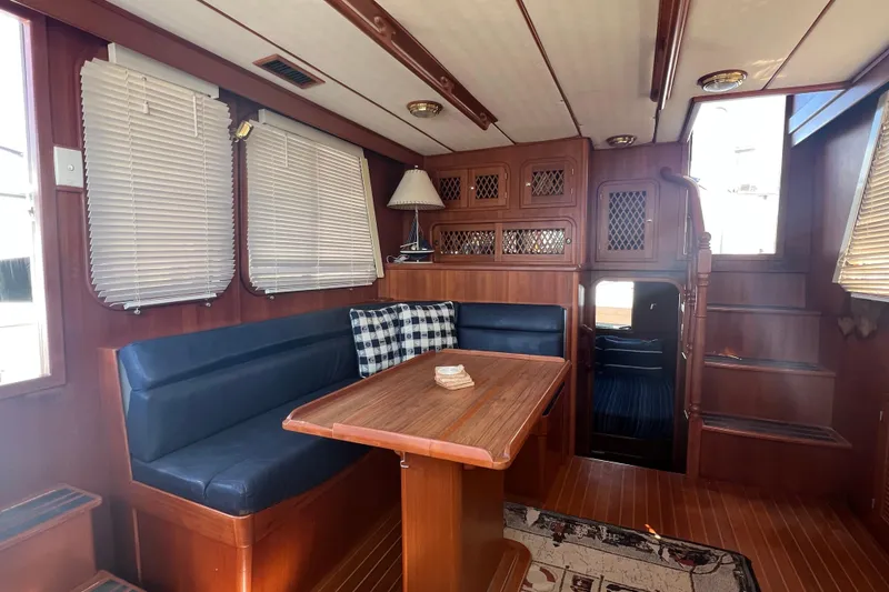 Slide: The Image of Interior of 2007 Heritage East Sundeck Trawler with wood paneling and cozy seating area. - 9