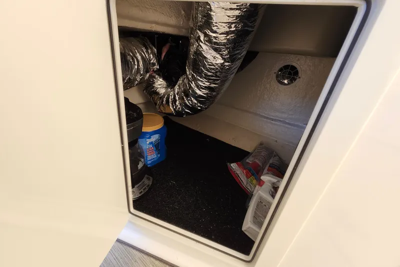 Slide: The Image of Storage compartment in a 2019 Regal 35 Sport Coupe with ductwork and supplies. - 10