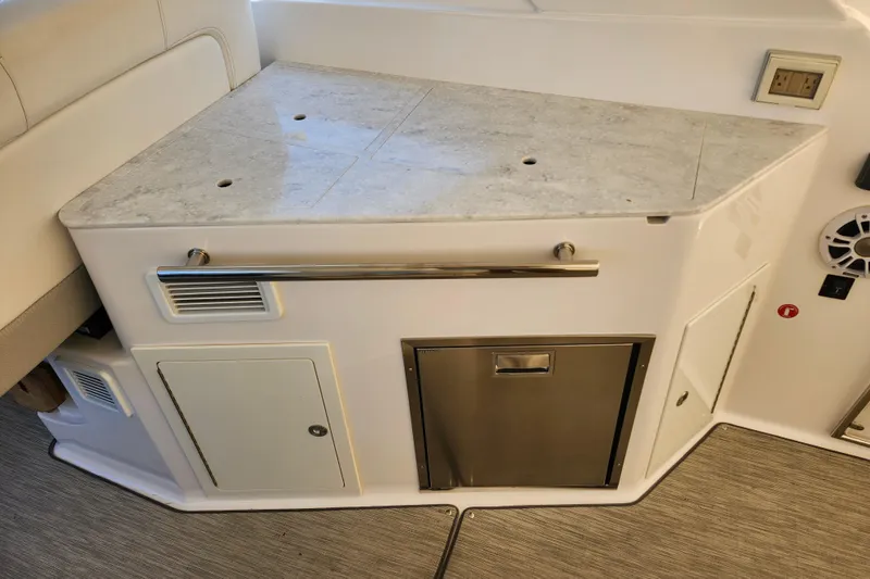 Slide: The Image of Interior view of a 2019 Regal 35 Sport Coupe yacht kitchen area with countertop and storage. - 7
