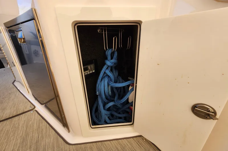 Slide: The Image of Storage compartment on a 2019 Regal 35 Sport Coupe with blue rope inside. - 8