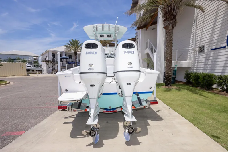 Slide: The Image of 2026 Albury Brothers 23 Forward Seating boat with twin 140 horsepower engines, docked outdoors. - 18