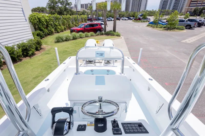 Slide: The Image of 2026 Albury Brothers 23 Forward Seating boat, showcasing helm and controls in a parking lot setting. - 42