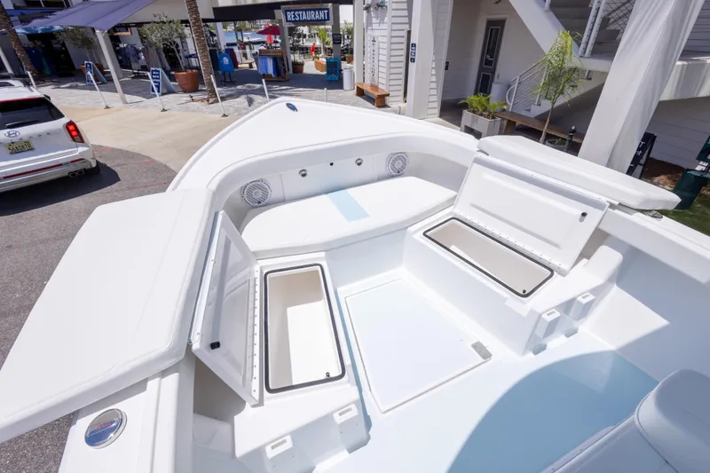Slide: The Image of 2026 Albury Brothers 23 Forward Seating boat with open storage compartments, docked near a restaurant. - 45