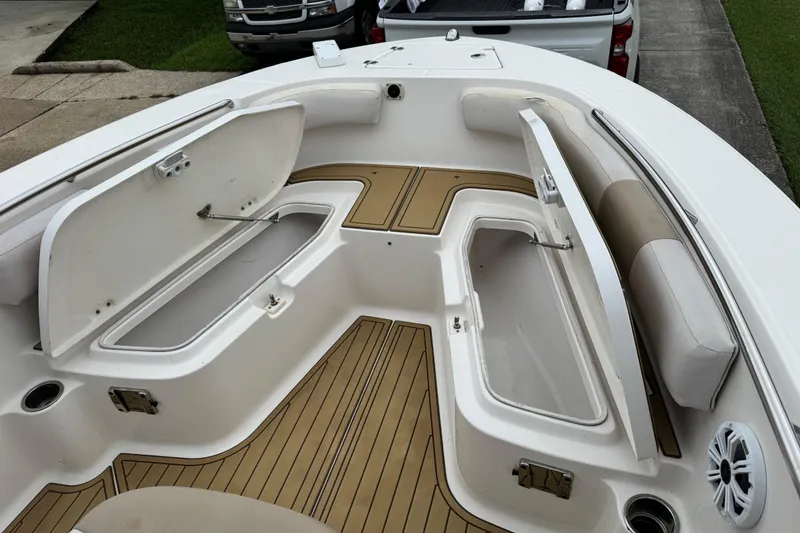Slide: The Image of 2017 Robalo R200 Center Console boat with open storage compartments and cushioned seating. - 22