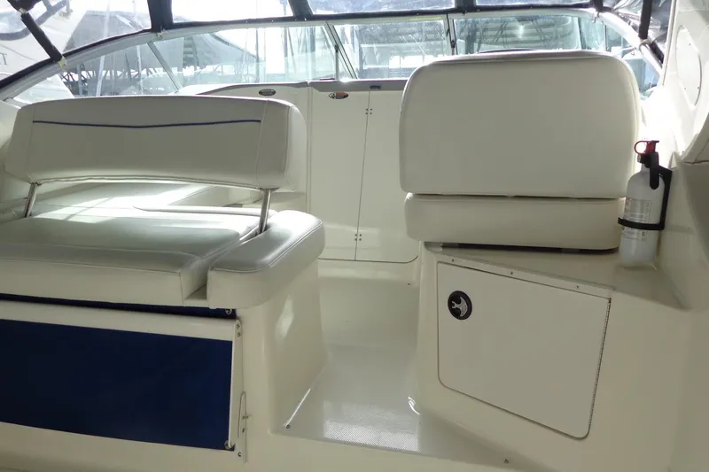 Slide: The Image of Interior of a 2007 Bayliner 285 boat with white seating and a fire extinguisher. - 11
