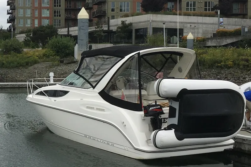 Slide: The Image of 2007 Bayliner 285 boat docked at marina with inflatable dinghy attached. - 2
