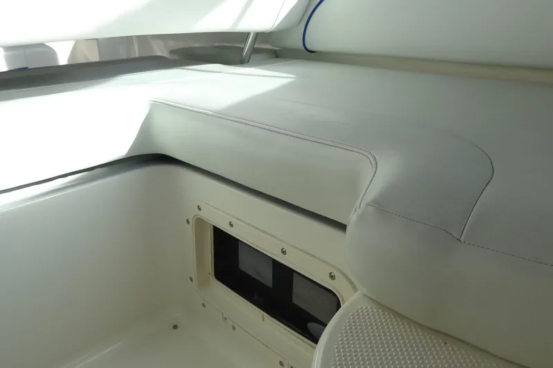 Slide: The Image of Interior seating of a 2007 Bayliner 285 boat, featuring white upholstery and storage compartment. - 20