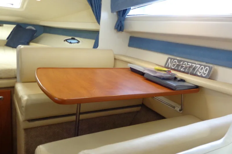 Slide: The Image of Interior of 2007 Bayliner 285 boat with cozy dining area and wooden table. - 24