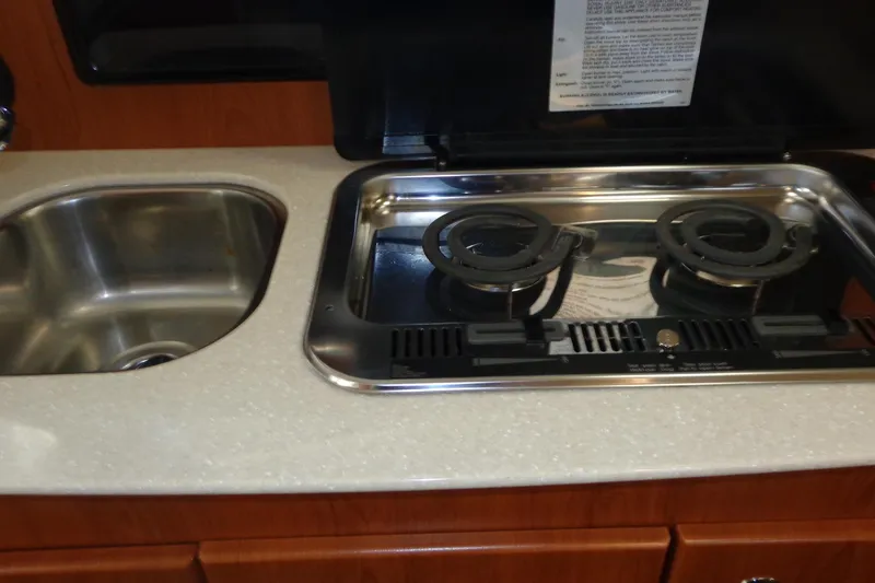 Slide: The Image of 2007 Bayliner 285 kitchen with stainless steel sink and dual-burner stove. - 27