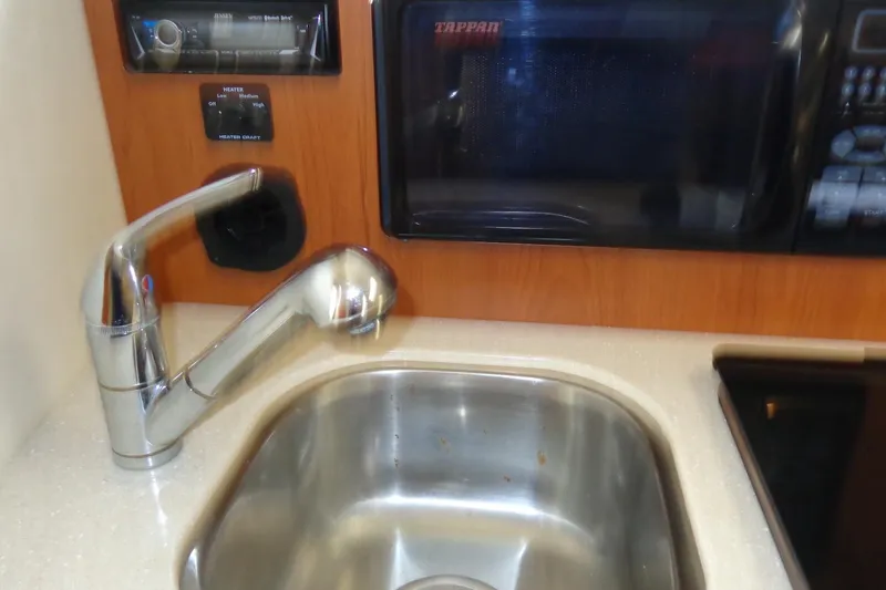 Slide: The Image of Compact kitchen area in a 2007 Bayliner 285 boat with sink and microwave. - 28