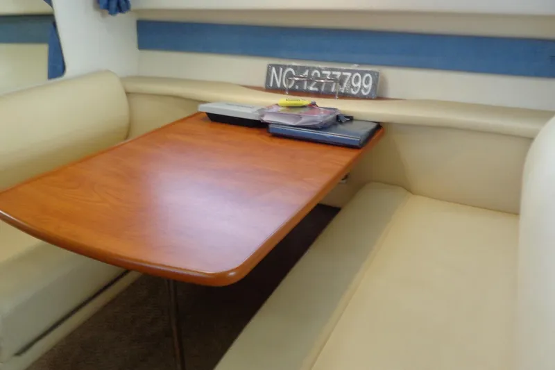 Slide: The Image of Interior of 2007 Bayliner 285 boat with wooden table and beige seating. - 29